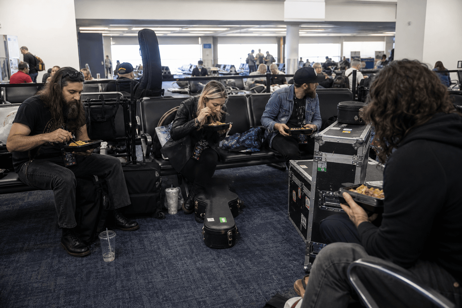 Touring crew with cases waiting at an airport gate