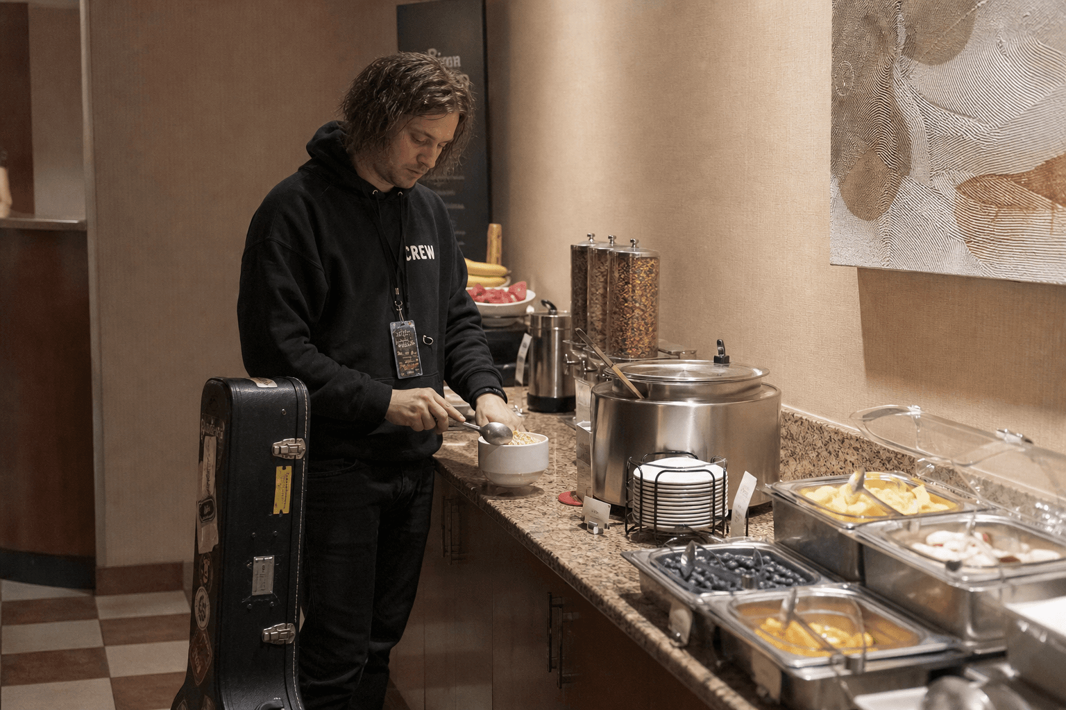 Roadie at a hotel breakfast bar with a guitar case